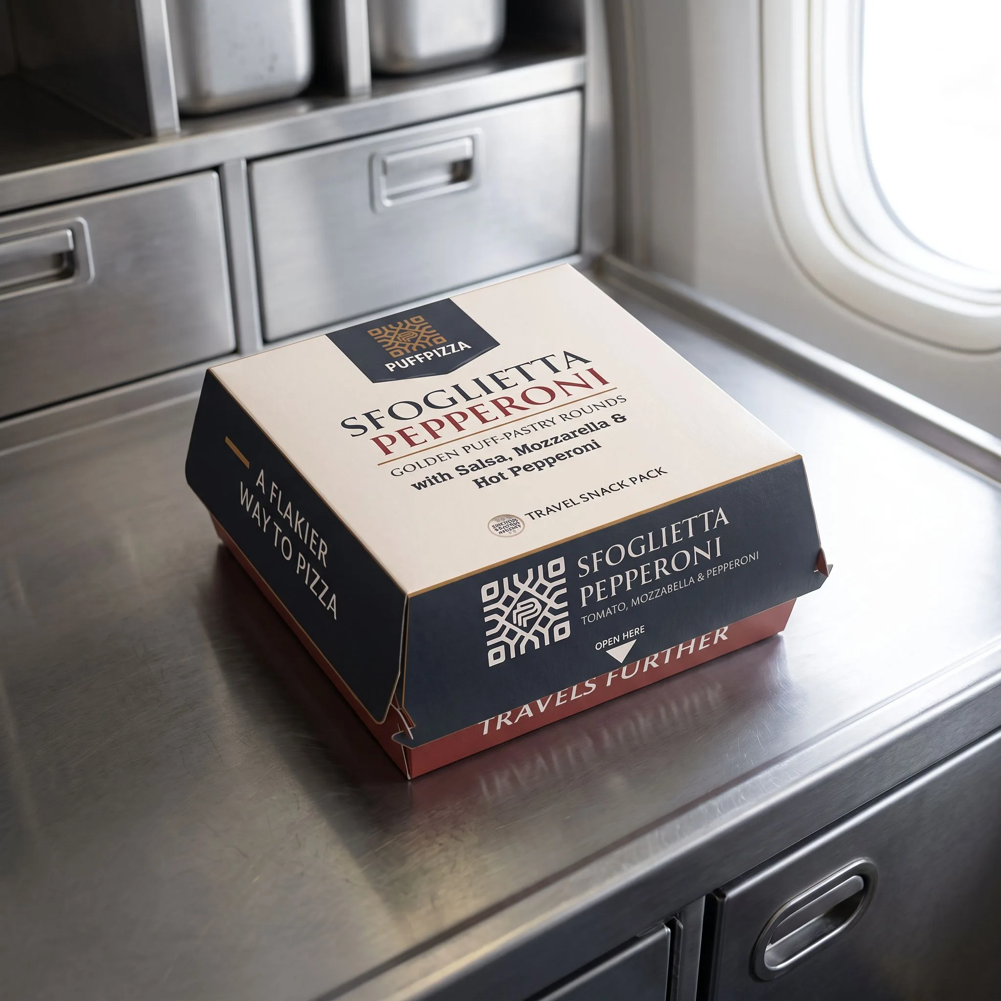 Sfoglietta® pepperoni airline travel snack carton by PuffPizza®, displayed in an aircraft galley. Premium single-serve packaging for Italian puff pastry pizza with tomato, Pepperoni and mozzarella.